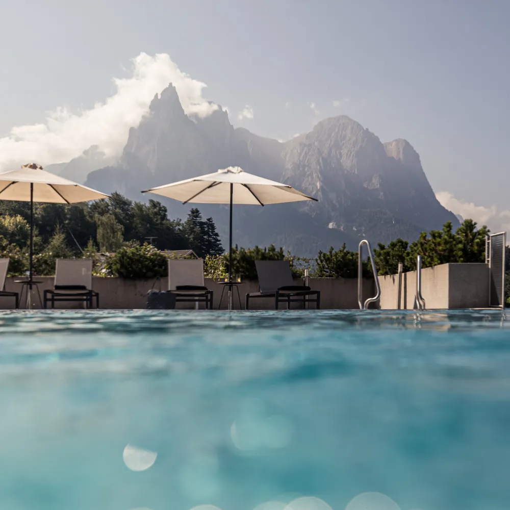 Infinity Pool at the Wellness Hotel Alpenflora with a view of the Dolomites at dusk