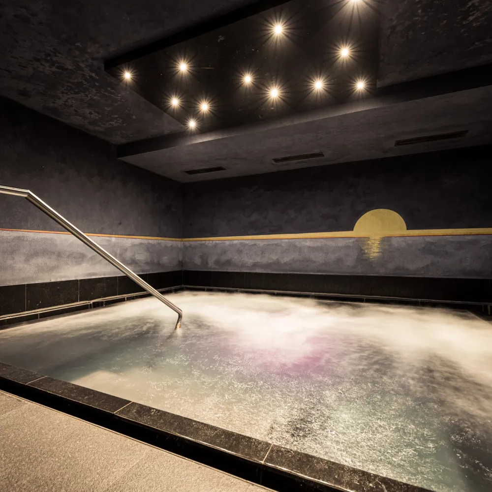 Solebad mit stimmungsvollem Licht im Wellnesshotel Alpenflora