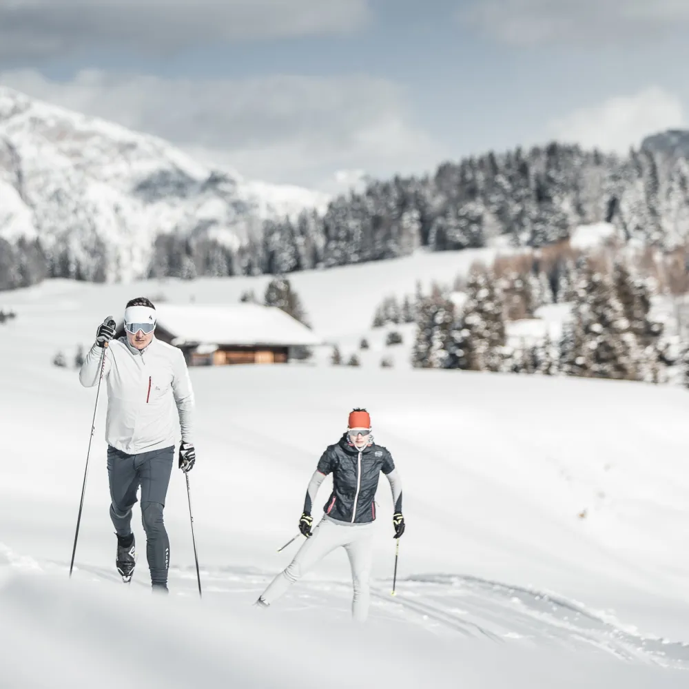 Cross-country skiing in the snowy landscape around Castelrotto with a view of the Dolomites