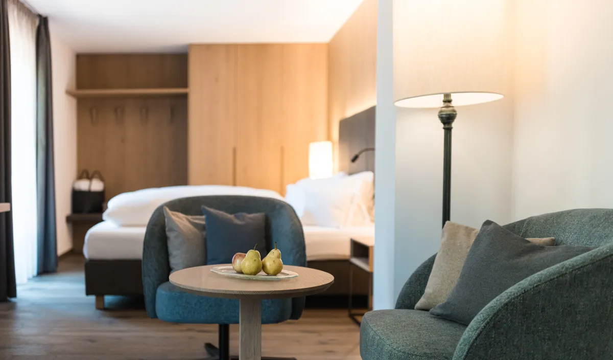 Sitzecke mit zwei Polstersesseln, Beistelltisch mit Obst und Stehleuchte im Doppelzimmer Classic.