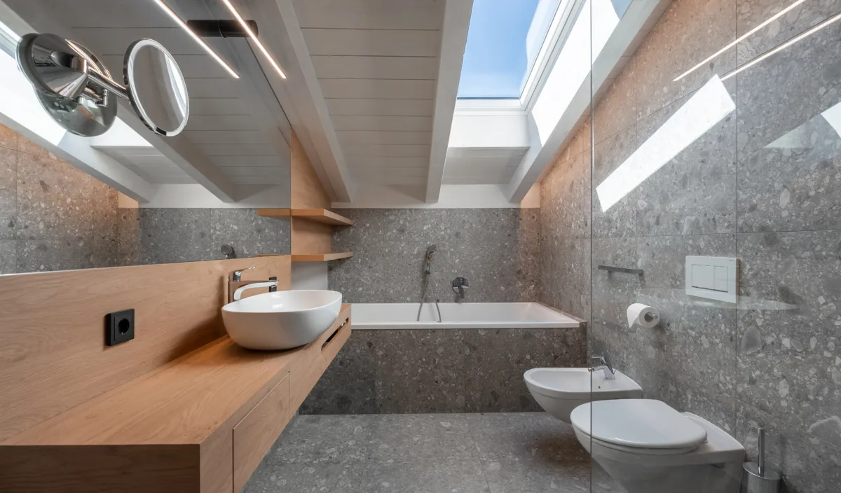 Bagno con lavabo, vasca da bagno, bidet, WC e lucernario con luce naturale nell'Attico Suite.