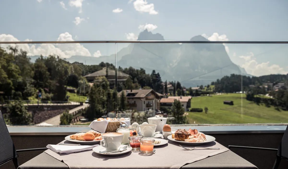 Gedeckter Frühstückstisch auf der Terrasse des Wellnesshotel Alpenflora mit Blick auf die Dolomiten