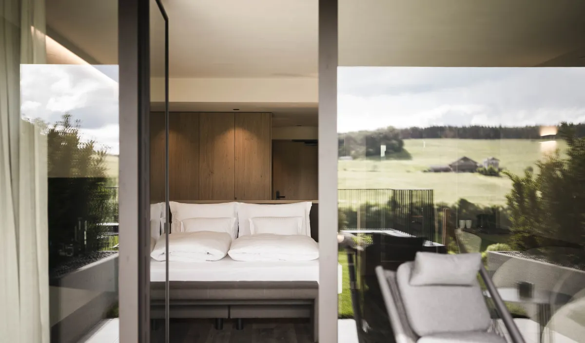 Garden Relax double room at the Alpenflora with bed, open bathroom and view of the greenery