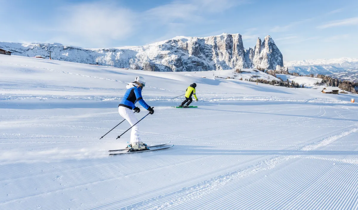 Skifahrer auf verschneiter Piste vor den Dolomiten bei Kastelruth