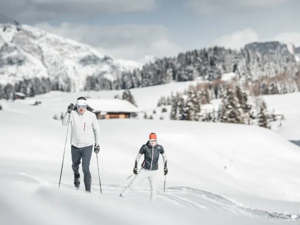 Zwei Personen beim Langlaufen im Schnee bei Kastelruth