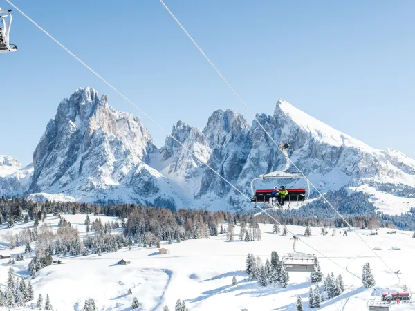 Sessellift vor den verschneiten Gipfeln der Dolomiten über der winterlichen Seiser Alm