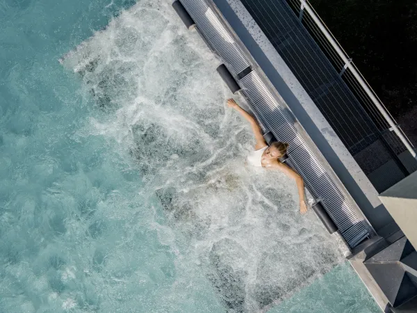 Person schwimmt von oben gesehen im sprudelnden Pool des Alpenflora