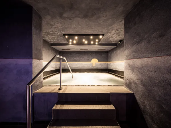 Solebecken mit warmem Licht und Treppe im Wellnesshotel Alpenflora